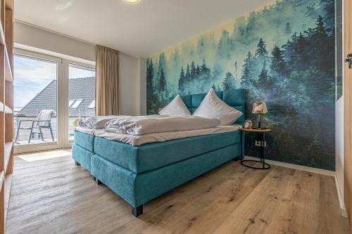 a bedroom with a blue bed with a large painting on the wall at Ferienwohnung Wiking-Koje 7 Schleswig in Schleswig