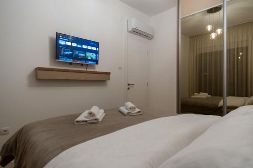 a bedroom with a bed with a tv on the wall at City Luxury in Trebinje