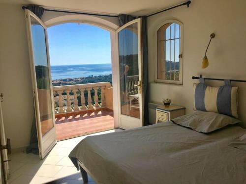 une chambre avec un grand lit et un balcon dans l'établissement Villa vue mer panoramique, à Sainte-Maxime
