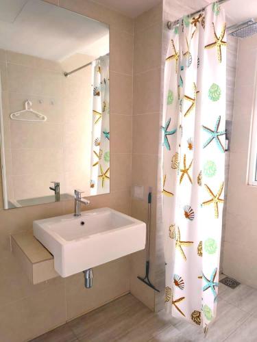 a bathroom with a sink and a mirror and a shower curtain at Windmill Upon Hills Premium Suite By Rapi Stay in Genting Highlands