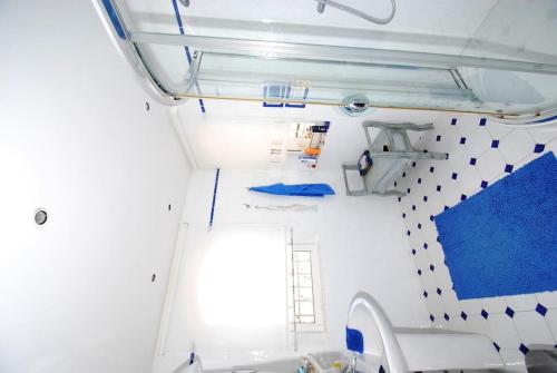 La salle de bains est pourvue d'un lavabo et d'un mur bleu et blanc. dans l'établissement Villa vue mer panoramique, à Sainte-Maxime