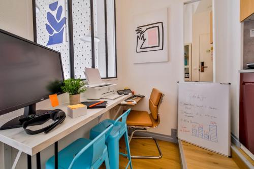 un bureau avec un bureau, un ordinateur et des chaises dans l'établissement WS Haussmann - La Fayette, à Paris