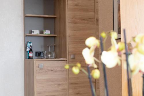 a wooden cabinet in a room with yellow flowers at Flair Hotel Deutsches Haus in Arendsee