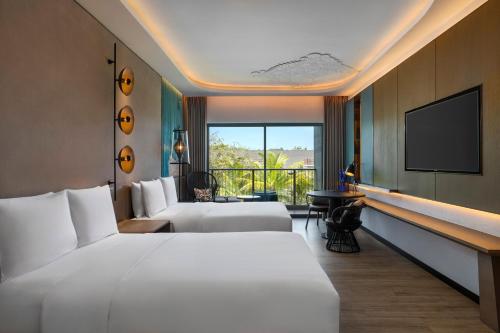 a hotel room with two beds and a flat screen tv at Renaissance Bali Nusa Dua Resort in Nusa Dua