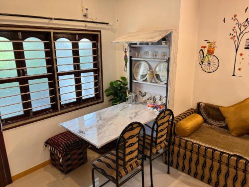 a living room with a table and a couch at The Homeland Stay in Ahmedabad