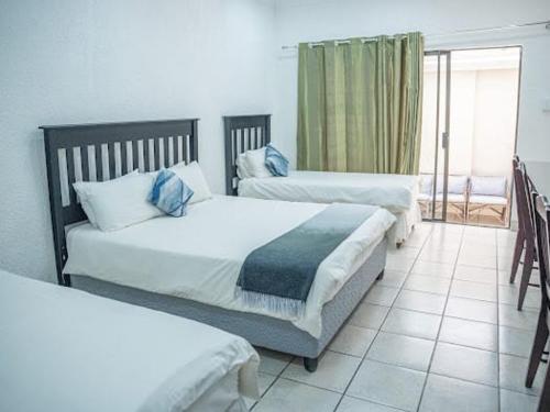 una camera da letto con due letti con cuscini blu di 196 On Victoria Bed & Breakfast a Newcastle