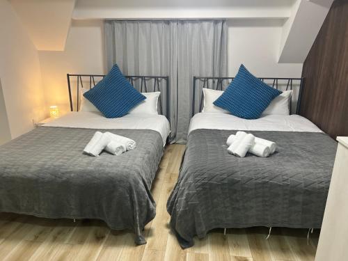 two beds in a room with blue and white pillows at Ikebukuro Area R2 NishiikeApartment 5F No Elevator in Tokyo