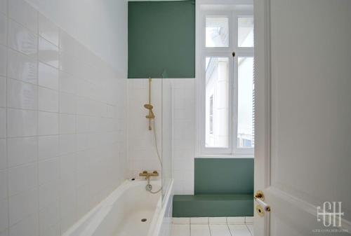 une salle de bain avec une baignoire et une fenêtre dans l'établissement Le Wilson - Proche Centre Ville, à Tours