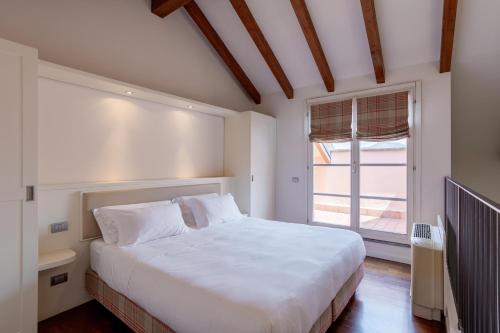 a bedroom with a large white bed and a window at Resort Antico Verbano in Meina