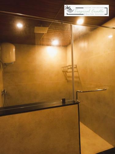 a shower with a glass door in a room at Tropical Cradle @ River Dale in Kalyānpur