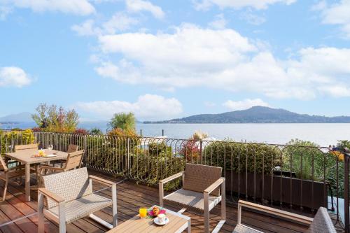 a patio with tables and chairs and a view of the water at Resort Antico Verbano in Meina