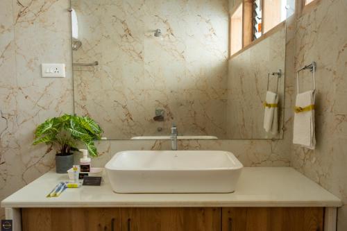 a bathroom with a sink and a mirror at Reunion Ocean Elite - Beach House in Udupi