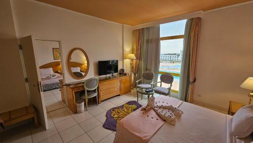 a hotel room with a bed and a mirror at Amarina Sun Resort & Aqua Park Sharm El-Sheikh in Sharm El Sheikh