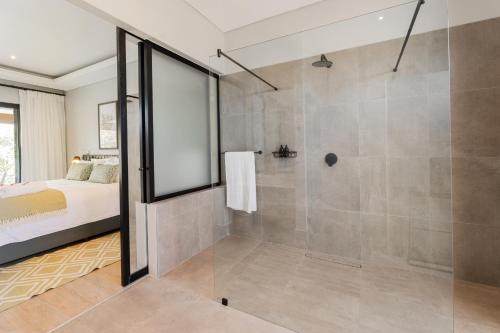 a large bathroom with a shower and a bed at Hotel Olivewood in East London
