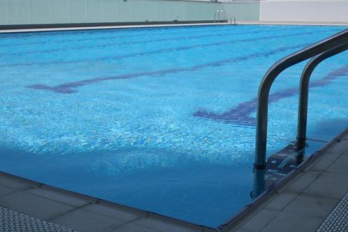 a large blue swimming pool with blue water at EC Holiday Homes Dubai Al Furjan in Dubai