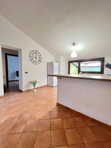 eine Küche mit Fliesenboden und einer Uhr an der Wand in der Unterkunft Casa Sopra in Castel di Sangro