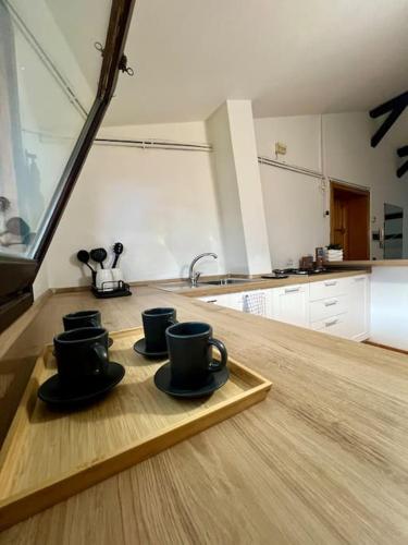 drei Kaffeetassen auf einem Tablett auf einer Küchentheke in der Unterkunft Casa Sopra in Castel di Sangro