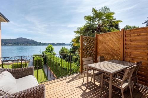 a deck with a table and chairs and a view of the water at Resort Antico Verbano in Meina