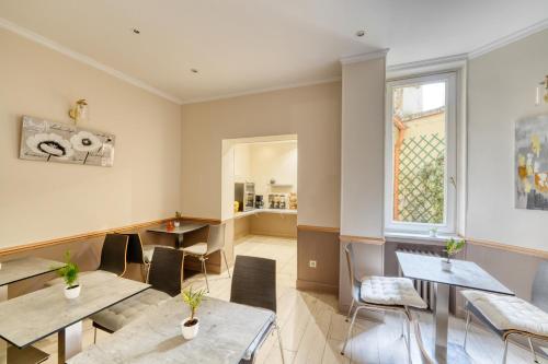 un restaurant avec des tables et des chaises et une fenêtre dans l'établissement Hotel Phenix Paris, à Paris