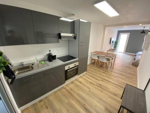 - une cuisine avec un évier et une table dans une chambre dans l'établissement L Angelus, à Lourdes