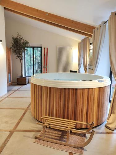 - une grande baignoire en bois dans une chambre avec un banc dans l'établissement Lyon Country House - Suites & Tour de Garde, à Caluire-et-Cuire