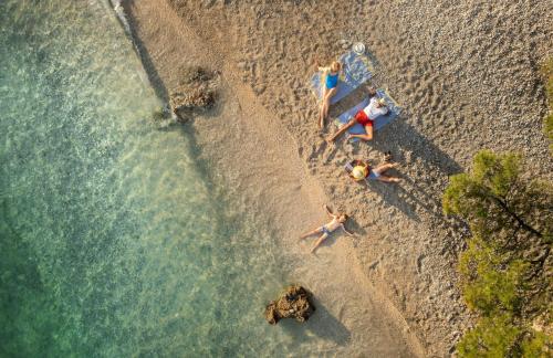 an overhead view of people swimming on a beach at Sunny Makarska by Valamar in Makarska