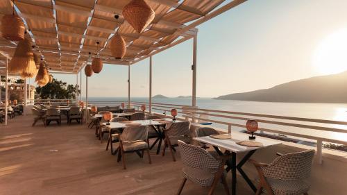 a restaurant with tables and chairs and a view of the ocean at Soothe Hotel in Kalkan