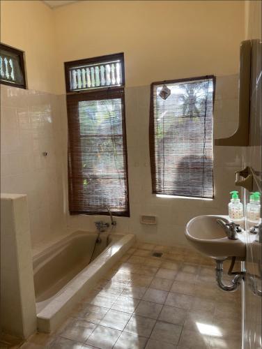 a bathroom with a tub and a sink at Desaka Bisma Ubud in Ubud