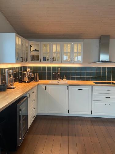 a kitchen with white cabinets and wooden counter tops at Ilulissat Stay - Seawatch Retreat in Ilulissat