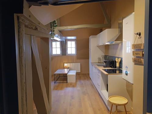 une cuisine avec des armoires blanches et un plancher en bois dans l'établissement Apt du Eau, à Rouen