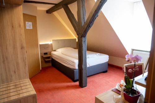 a small bedroom with a bed and a tree in it at Flair Hotel Deutsches Haus in Arendsee