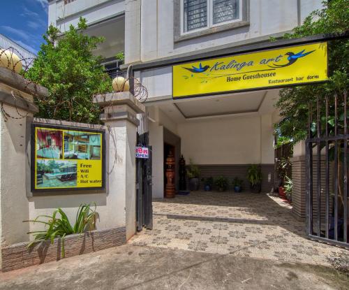 a building with a yellow sign on the side of it at Kalinga Art Home Guest House in Siem Reap