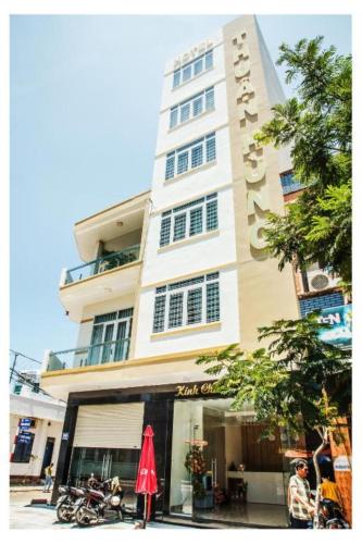 a tall building with a red umbrella in front of it at H Hotel in Quy Nhon
