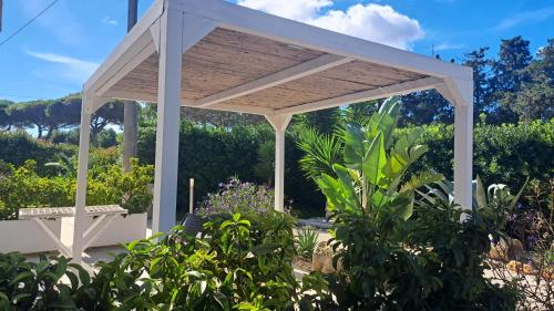 a white pergola with a bench in a garden at Giardino D'Oriente in Otranto