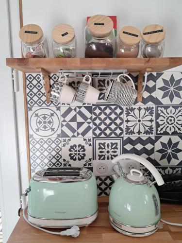 - une étagère avec des casseroles et des poêles dans la cuisine dans l'établissement Au doux rêve, à Puyfebert