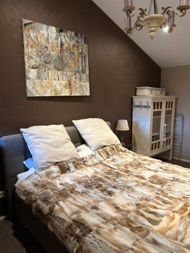 a bedroom with a large bed and a painting on the wall at Veld en Bosch in Leusden