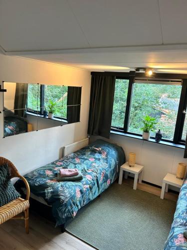 a bedroom with a bed and two windows at Studio Enschede Twente - Rust, natuur & gratis parkeren in Enschede