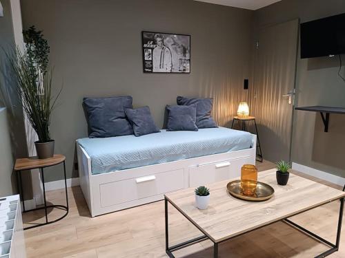 - une chambre avec un lit doté d'oreillers bleus et d'une table dans l'établissement Apt Robec, à Rouen