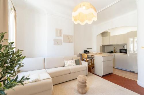 un salon avec un canapé blanc et une cuisine dans l'établissement 1BR Cosy 2min from Old Port | By Airnest, à Marseille