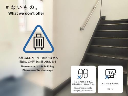 a sign in a stairwell with a trash can at Little Japan in Tokyo
