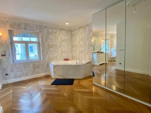 a large bathroom with a tub and a window at Pétrusse Élite Suites in Luxembourg
