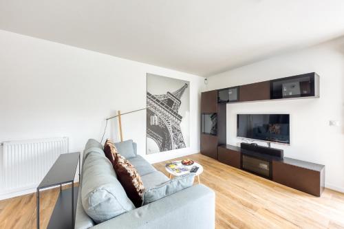 a living room with a couch and a tv at l'Escale Disney à votre porte in Lagny
