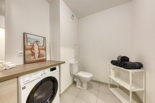 a laundry room with a washing machine and a toilet at l'Escale Disney à votre porte in Lagny