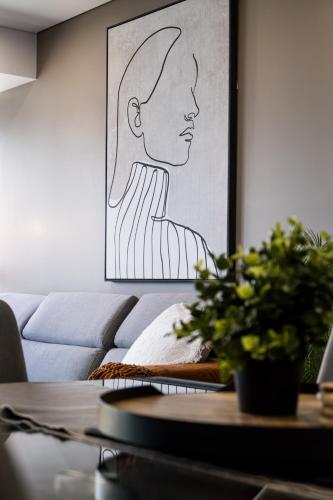 a living room with a table and a painting of a woman at Infinity Tower Brisbane City in Brisbane