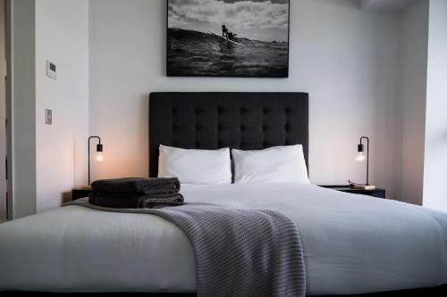 a bedroom with a large white bed with two lamps at Infinity Tower Brisbane City in Brisbane
