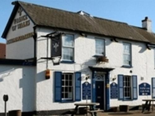 a white and blue building with a picnic table in front of it at The Prince of Wales in Huntingdon