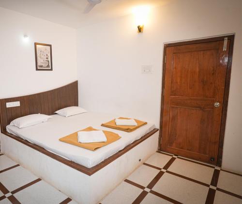 a bedroom with a bed and a wooden door at Malama Stay The Nest Villa 5BHK Kashid in Kashid