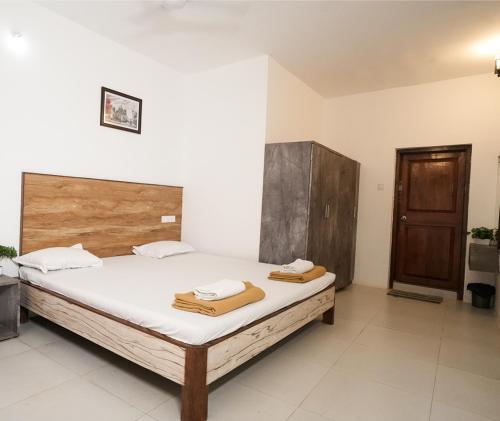 a bedroom with a bed with two towels on it at Malama Stay The Nest Villa 5BHK Kashid in Kashid