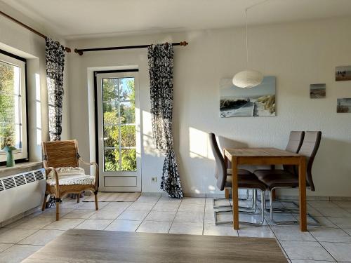 a dining room with a table and chairs and a window at Nordsee Huus in Friedrichskoog-Spitz