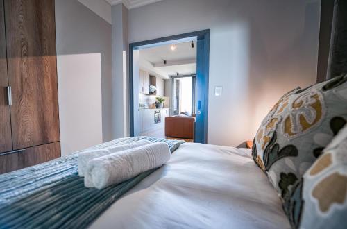a bedroom with a bed with two towels on it at Luxury Beachfront Studio in Blouberg in Bloubergstrand